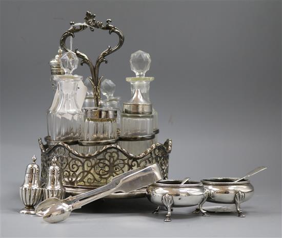 A pair of Victorian silver cauldron salts, a pair of silver peppers, sugar tongs. two spoons and a plated 7-bottle cruet